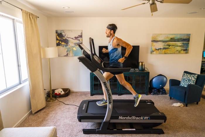 Zach Bitter in headband and tank running 100 miles on treadmill