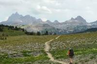 Backpacking Essentials for Your Overnight Hike hiker on an open singletrack trail in Grand Tetons national park