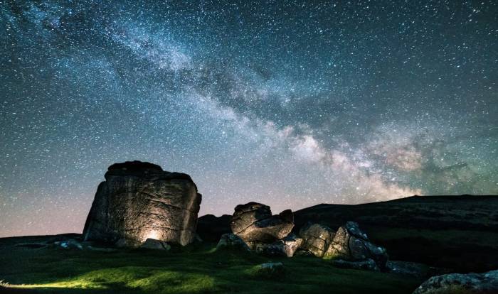 night light and starry skies over field of boulders