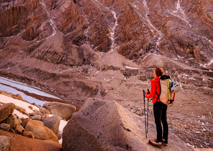 Hiker in canyon with trekking poles.