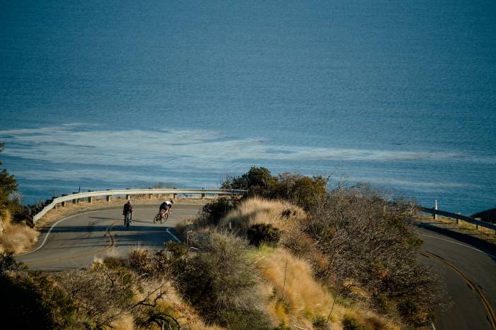 People road cycling with ocean