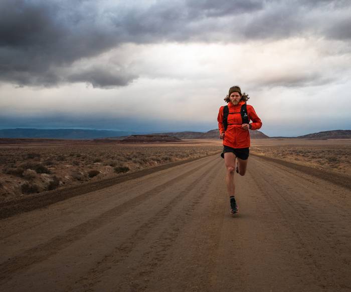 Man Running on a gravel road in Black Diamond gear
