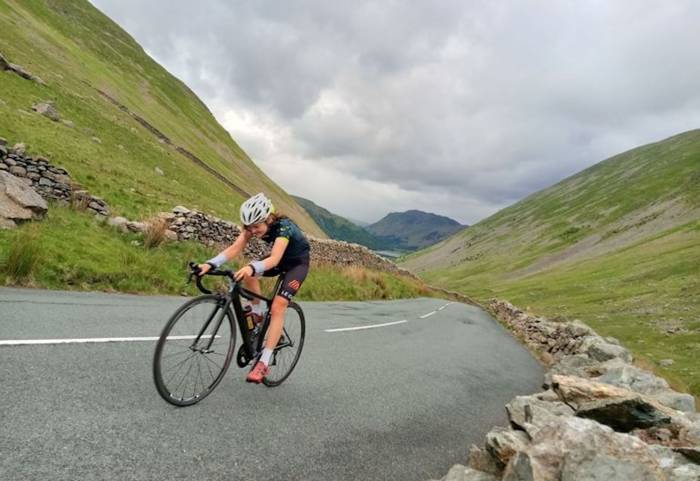 cyclist hannah rhodes-patterson riding hard up paved mountain road