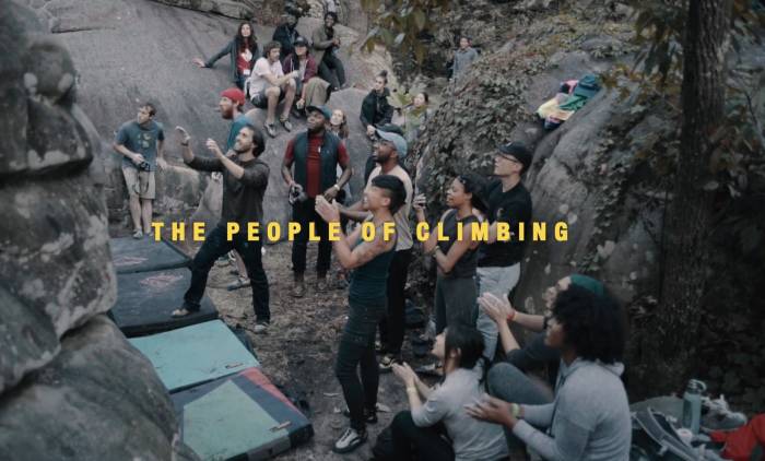 group of Black and brown people cheering on climber at a boulder crag