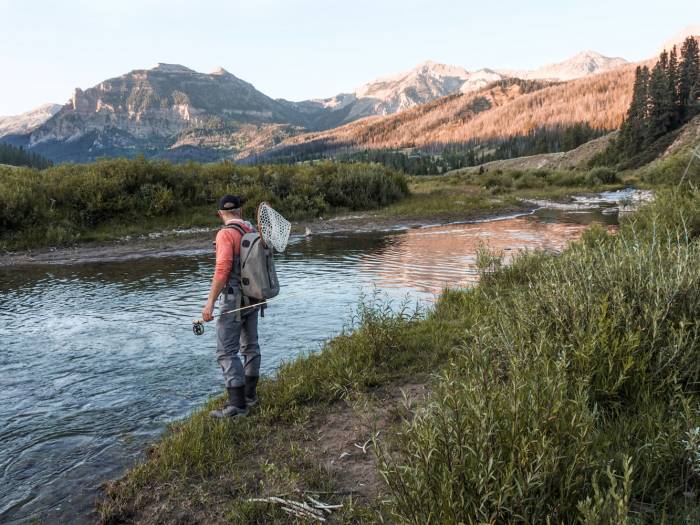 Person Fishing in a Simms Fly Fishing Hoody Simms Waders and boots