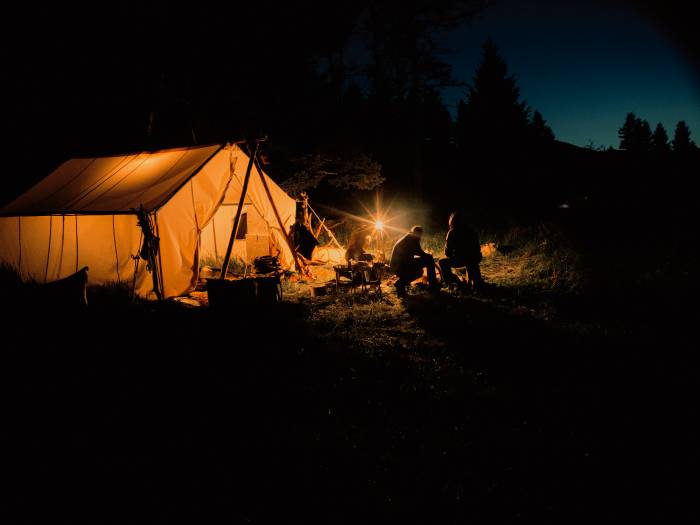 canvas tents lit up with a yellow glow at night