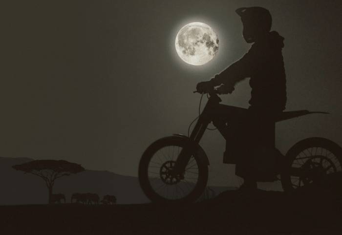 silhouette of rider in moto-helmet on a CAKE electric bush bike