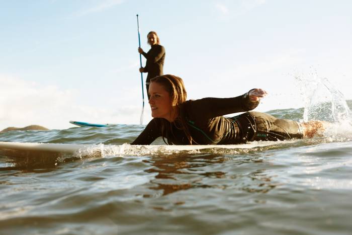 woman paddling on board, man on SUP