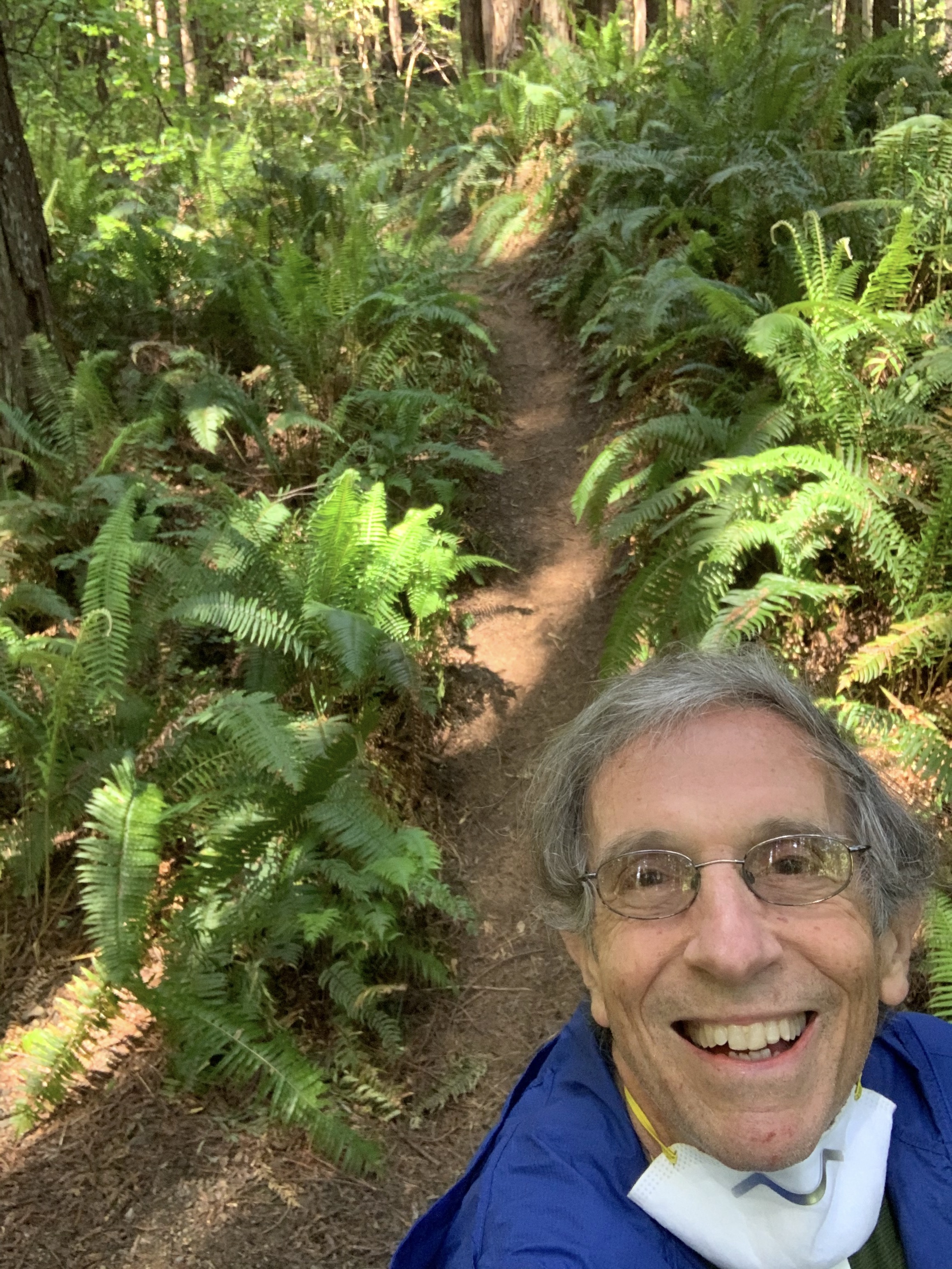 Eric Spector running Black Mountain Eric Spector taking a selfie while running along a lush singletrack trail