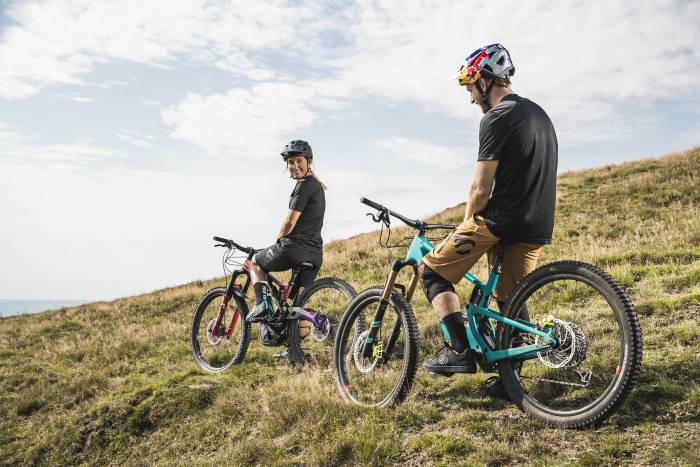 two mountain bikers pausing along ridge of trail