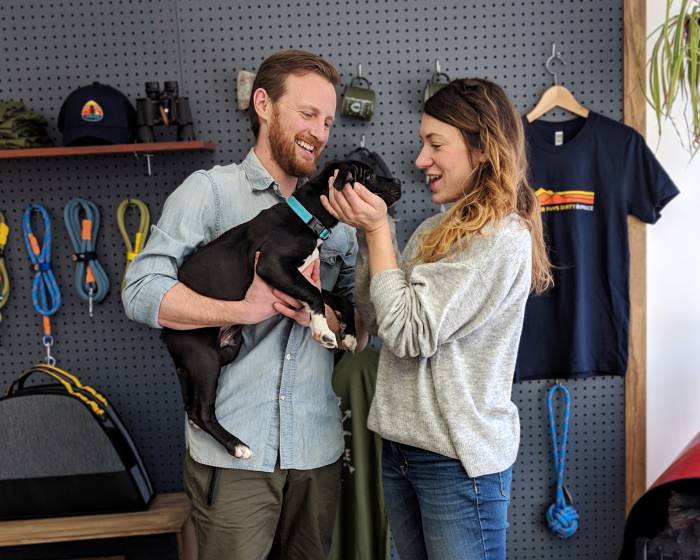 Spruce founders Eli and Leah together holding their puppy