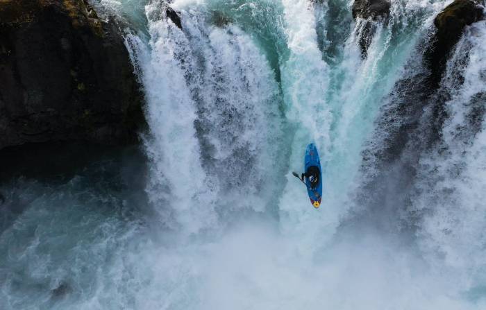 Nouria Nouman in blue kayak going down massive waterfall