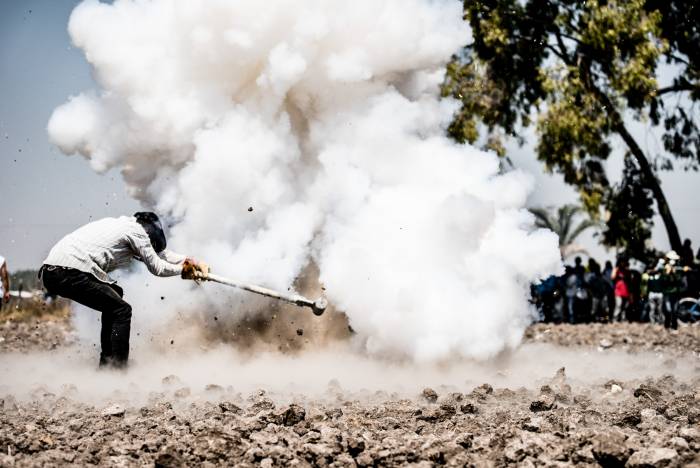 man with a giant hammer and dust cloud explosion