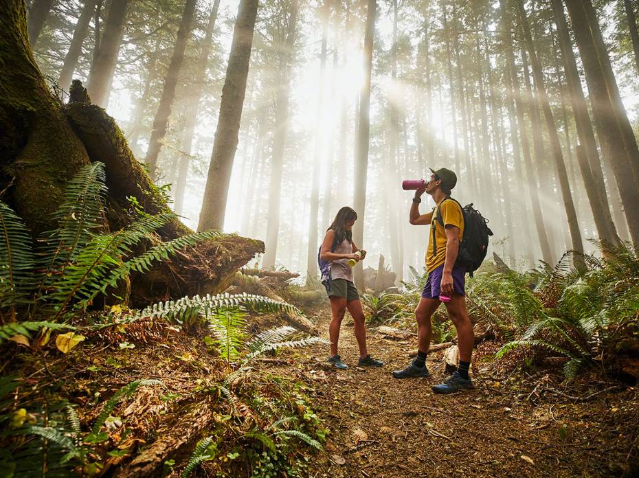 Hydro Flask Drops Limited-Edition 'Giveback' Collection Bottles to Help Fund Trails two hikers in shorts on a forest trail