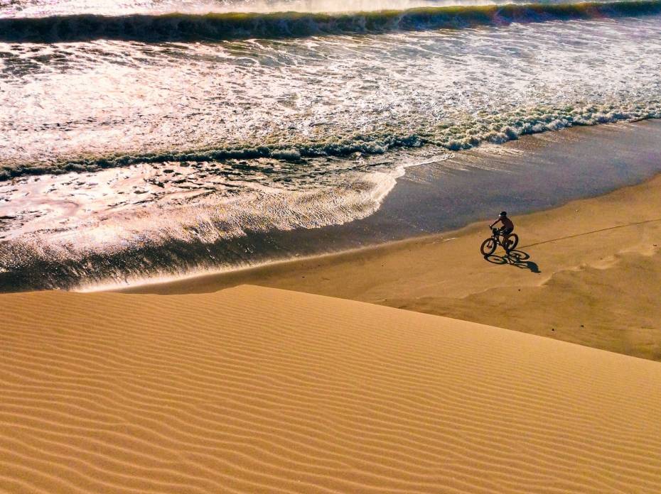 ‘Gates of Hell’ Bike Ride Spans 1,000 Miles With Snakes, Lions, and Quicksand Kate Lemming cycling across a Namibia desert beach