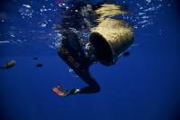 ben lacomte swimming through dark blue waters