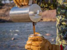 The Best Coffee for Camping and Backpacking in 2021 camper pouring coffee from stainless steel pourover