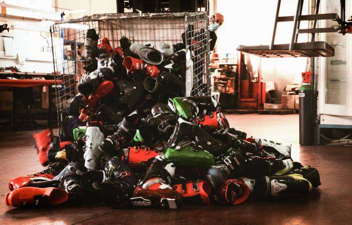 metal bin tipped over with Tecnica ski boots spilling out onto the floor