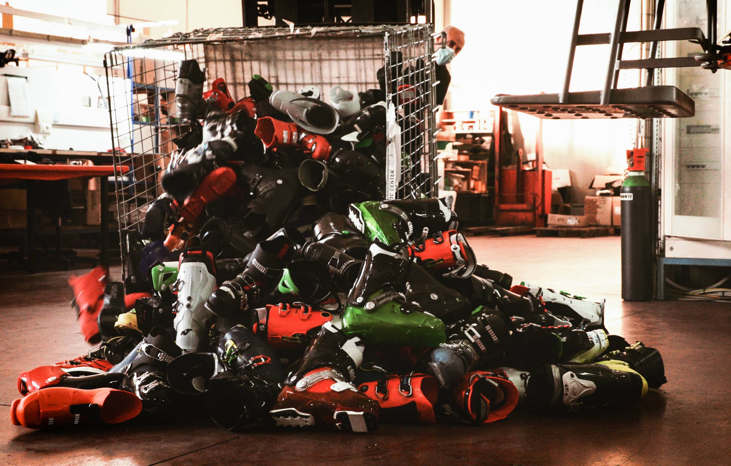 metal bin tipped over with Tecnica ski boots spilling out onto the floor