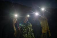 4 people wearing headlamps in the dark