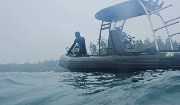 surfer in wetsuit on motorboat in vancouver, canada