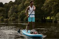 Calling All Artists: Submit a Sketch, Win a Paddleboard With Red Paddle Co. African American man in teal boardshorts paddleboarding on flatwater