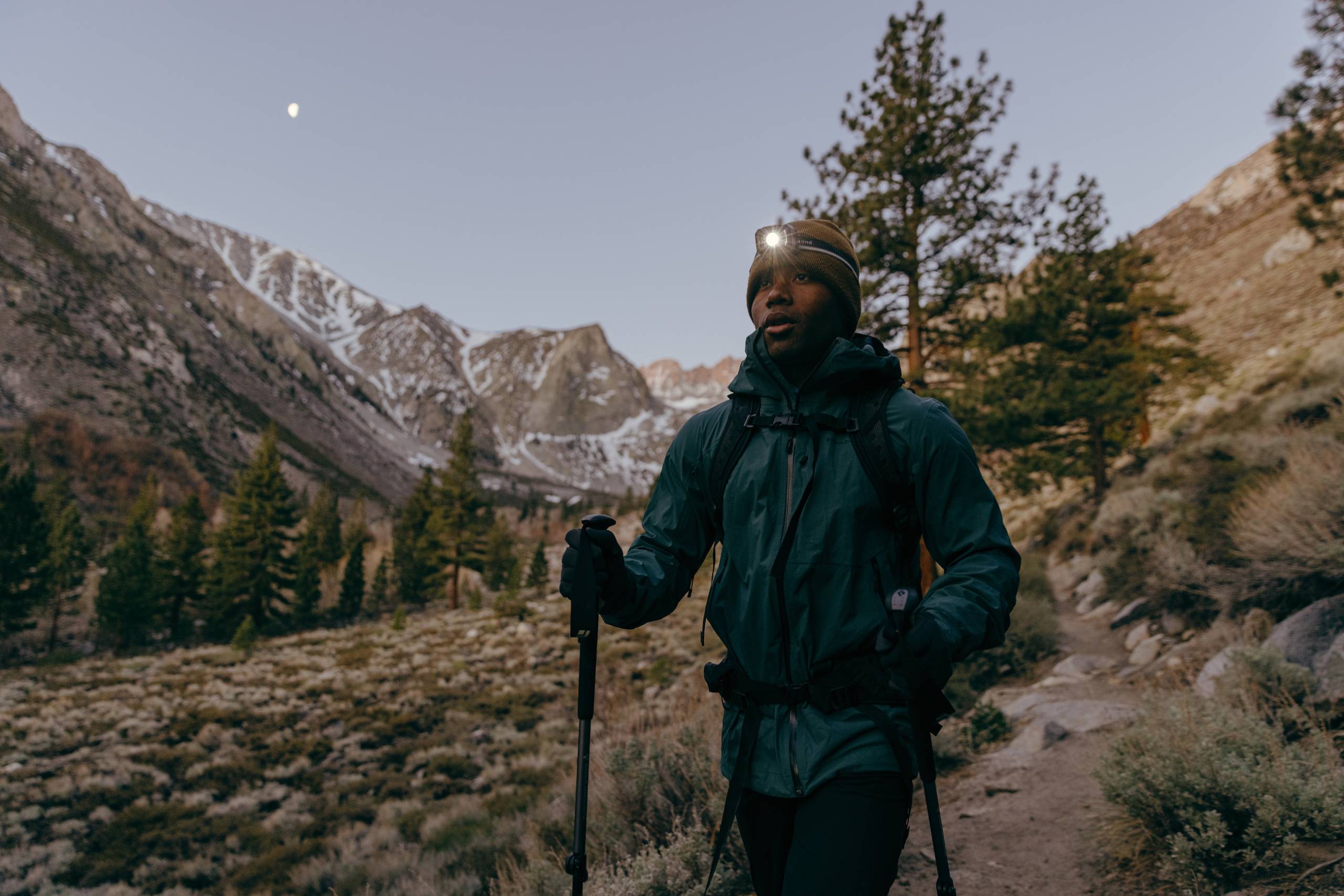 Andrew A. King hiking in mountains with the moon visible in the sky