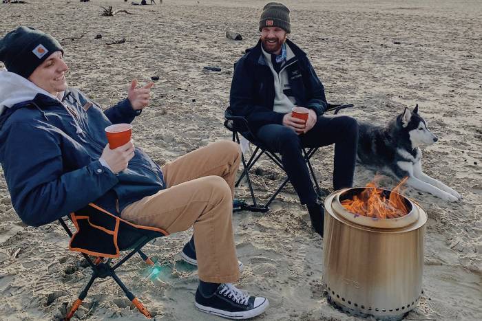 Two People On The Beach With Solo Stove Firepit
