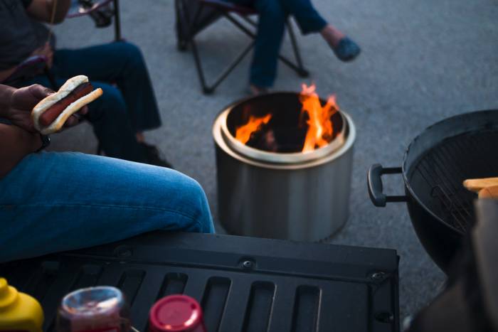 People sitting around solo stove fire pit eating