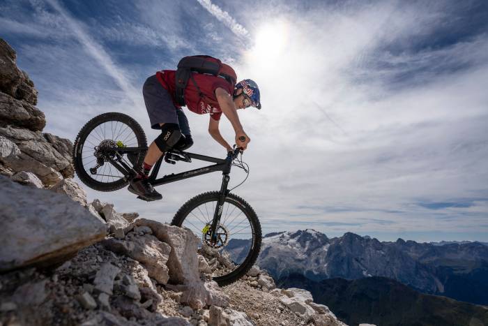 Tom Oehler mountain biking down steep rocky trail in Italy's Dolomites