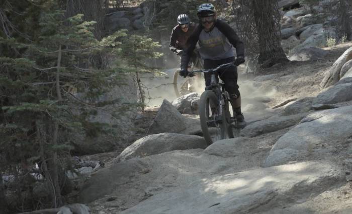 a dad and a grown son biking downhill