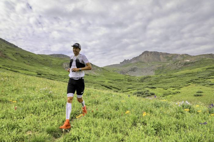 Hardrock 100 Endurance run winner François D’haene running over green alpine meadow