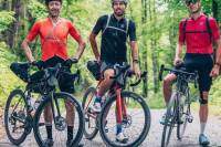 3 cyclists on their bikes paused in a roadway with their bikepacking gear