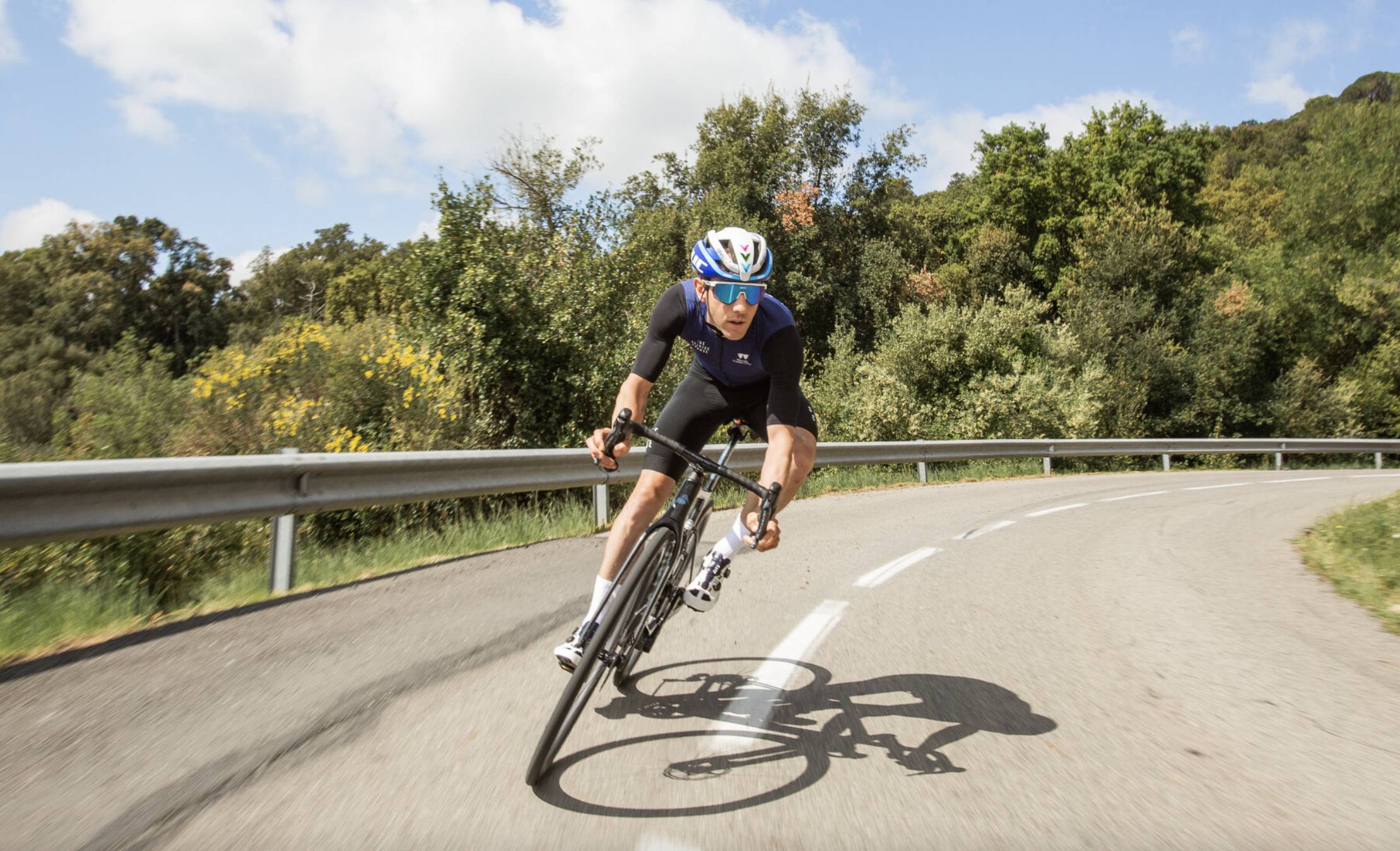 mike woods in "cardio club" navy jersey cycling through road curve