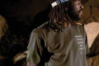 Learn a Chill, Mindful Running Routine With Rio Lakeshore rio lakeshore wearing green Roark shirt and wearing a Black Diamond headlamp looking off to his right in a dark cave