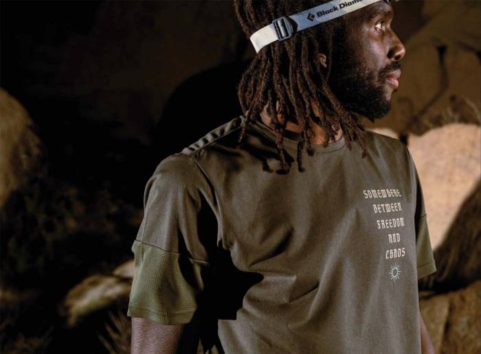 rio lakeshore wearing green Roark shirt and wearing a Black Diamond headlamp looking off to his right in a dark cave