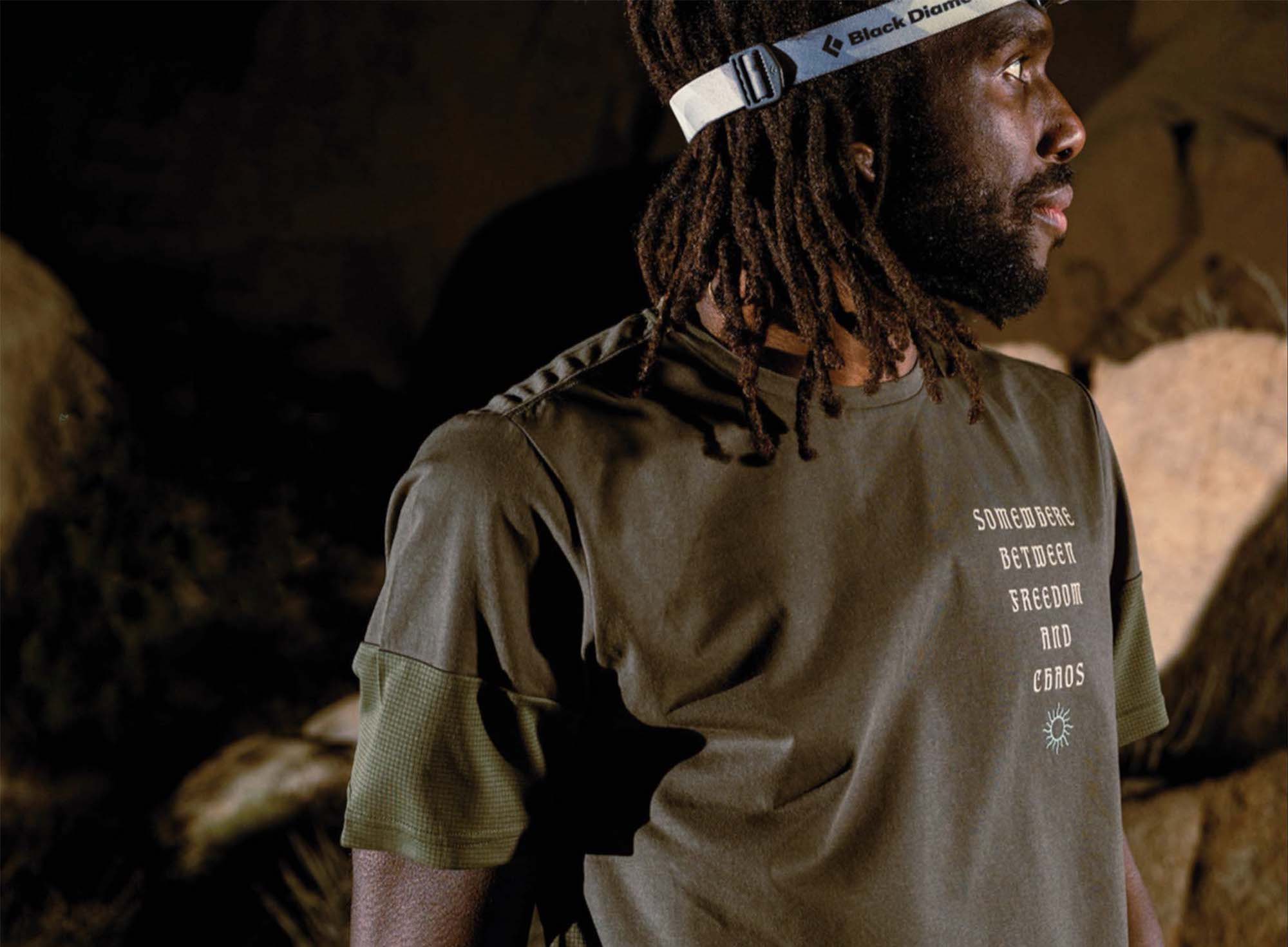 rio lakeshore wearing green Roark shirt and wearing a Black Diamond headlamp looking off to his right in a dark cave