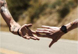 two runners reaching for each other's hands