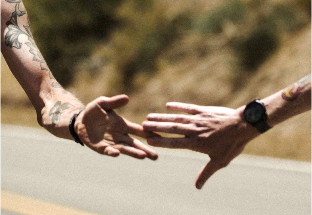 two runners reaching for each other's hands