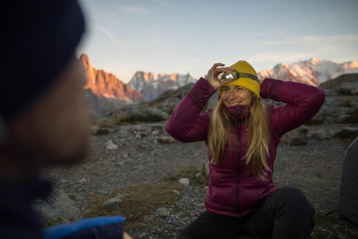 Woman wearing Forclaz Trek 900 jacket with headlamp