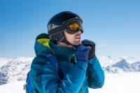 The Best Ski Helmets of 2021-2022 Man putting on ski helmet