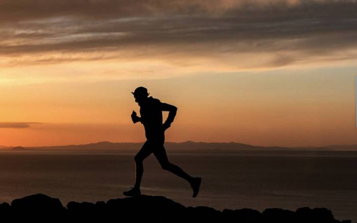 black silhouette of ultrarunner Trevor Fuchs against orange skyline