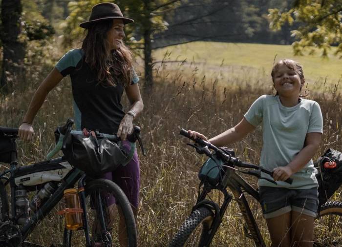 mother daughter duo Emily and Willow Zebel straddling their bikes and smiling