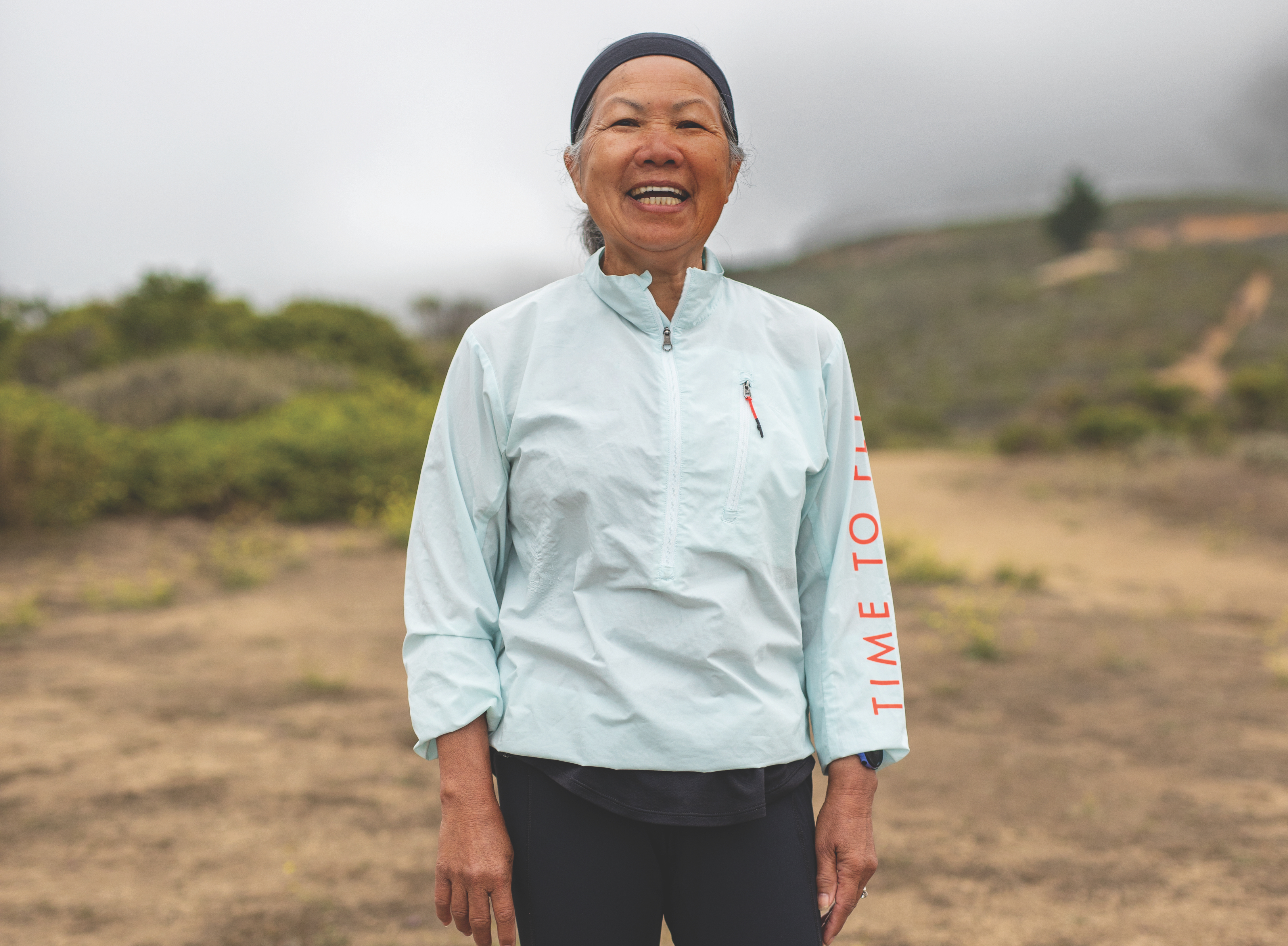 chau smith runner in a HOKA ONE ONE trail run jacket and headband smiling