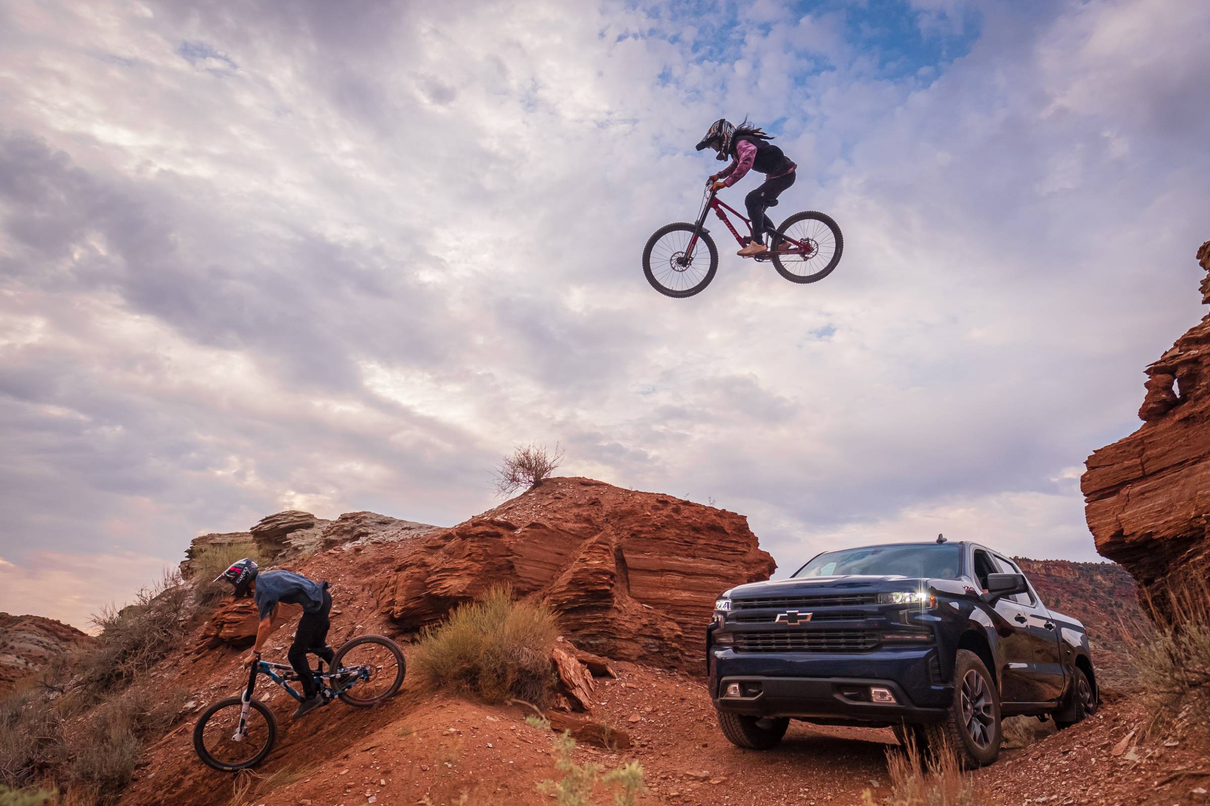 mountain biker hitting a road gap jumping over a chevy silverado