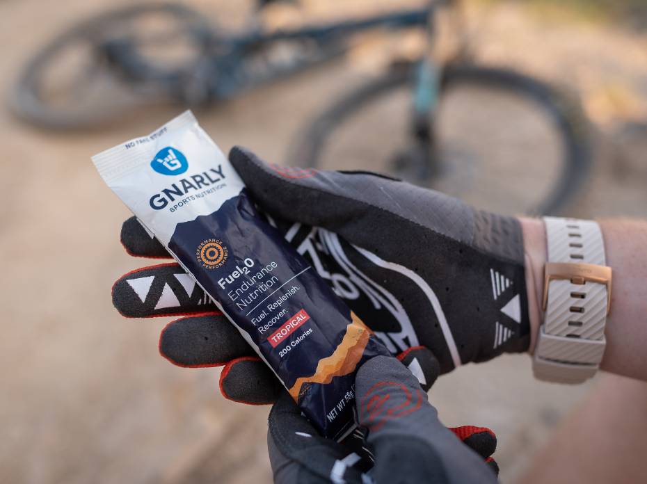 Mountain biker holding a packet of Gnarly Nutrition Fuel2O