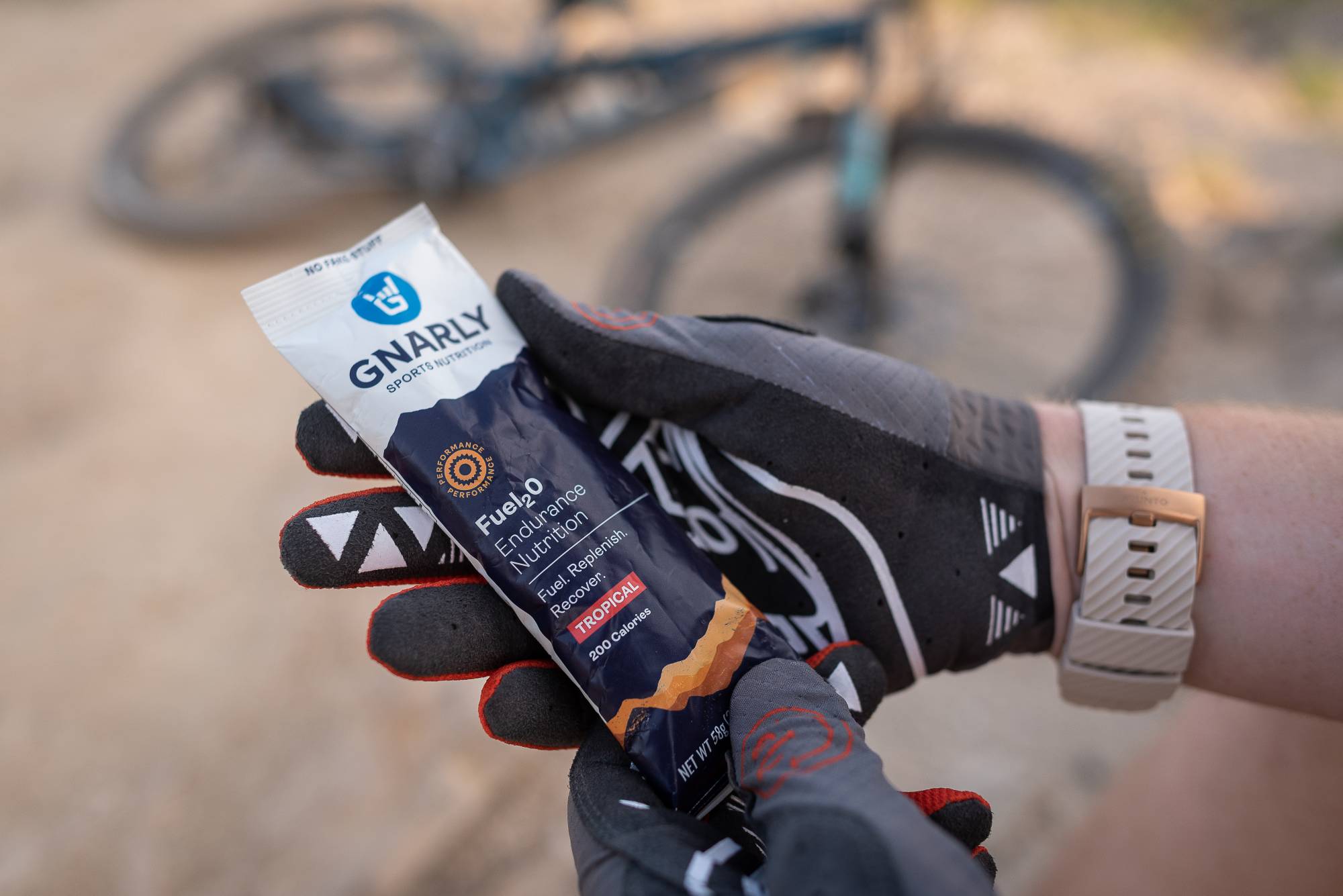 Mountain biker holding a packet of Gnarly Nutrition Fuel2O