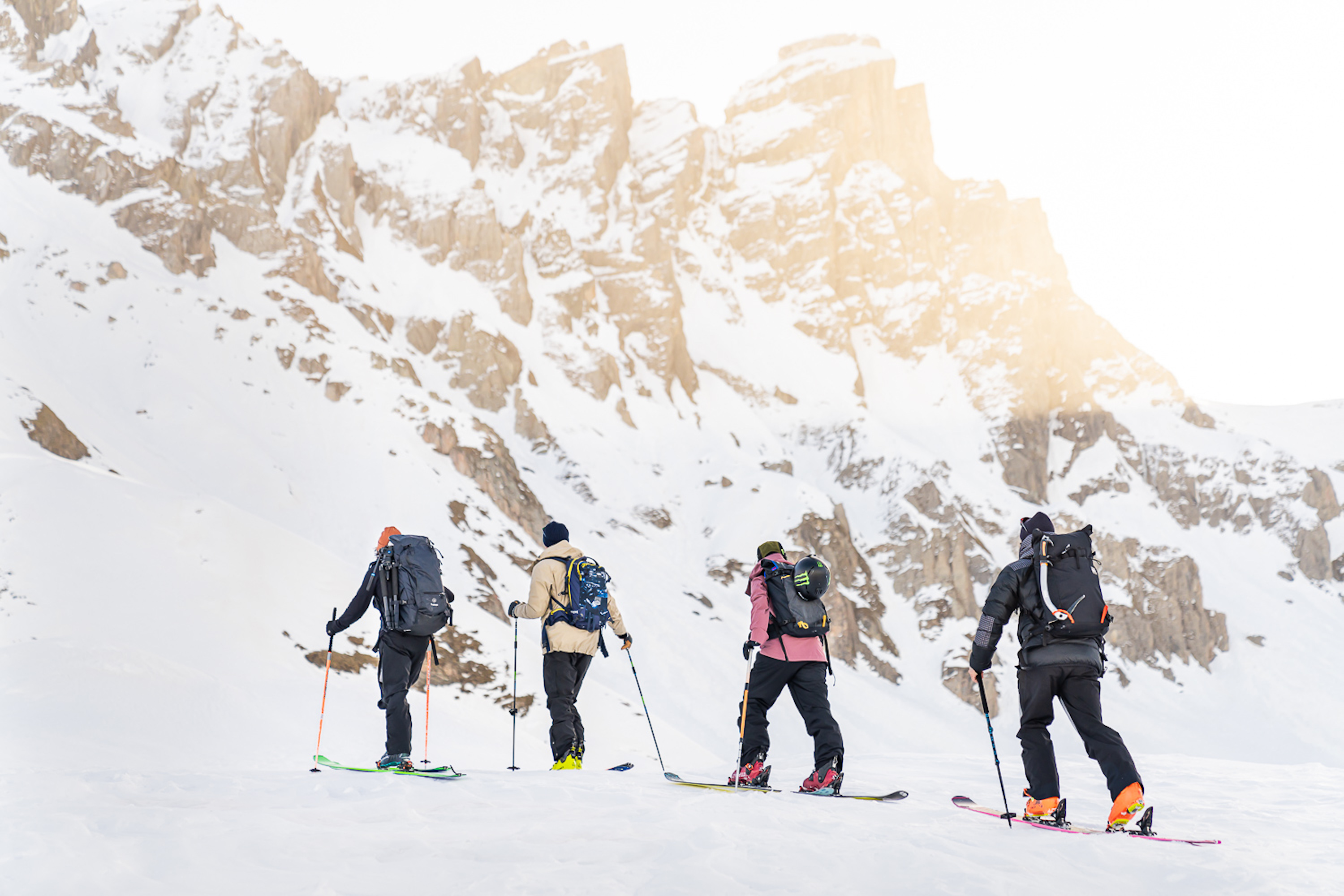 4 skiers traversing across a snowy landscape in the Alps of France