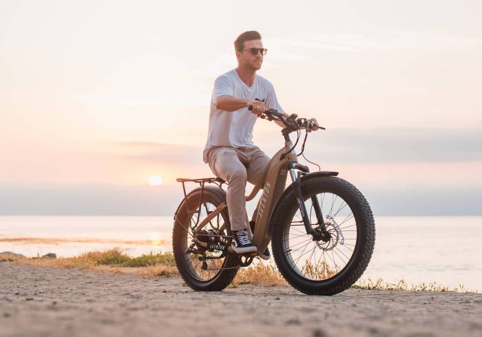Aventon adventure e-bike with man riding on a beach
