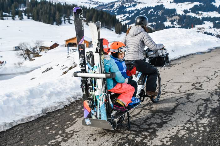 Yuba Spicy Curry V3 carrying a ski rack, skis, and two kids